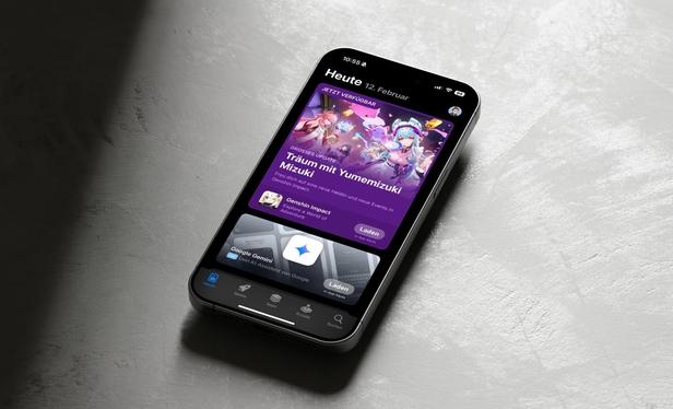 Startseite des deutschen App Stores auf einem iPhone, das auf einer grauen Betonoberfläche liegt.