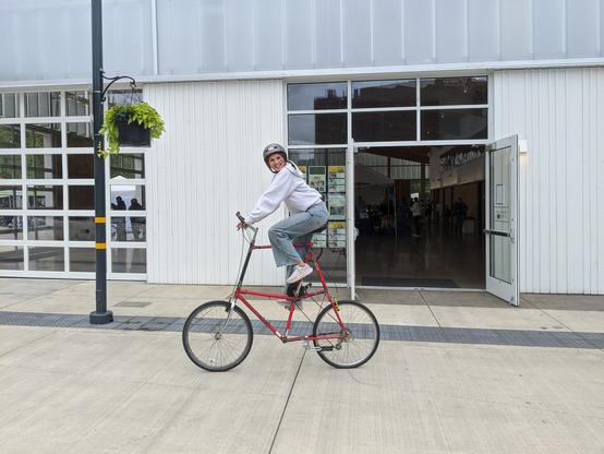woman rider on a red tall-bike.