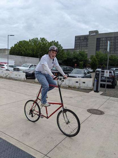 Man on a red tall bike
