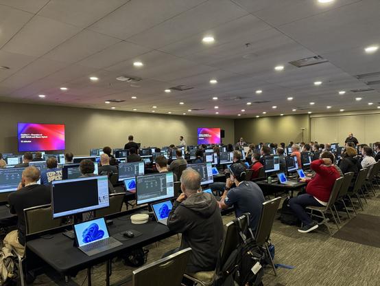 A room full of desks and computers with people following the Lab on building your first .NET MAUI and Blazor Hybrid app