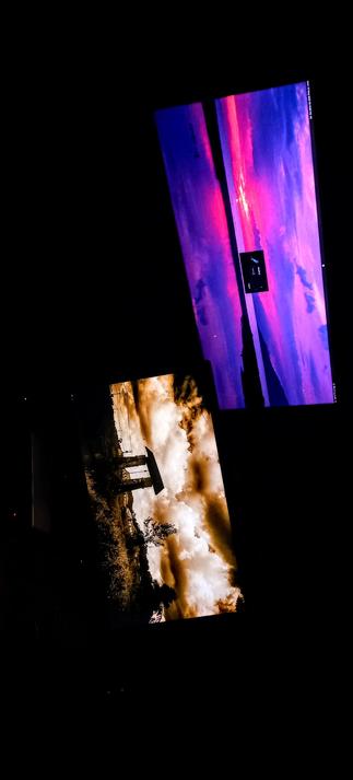 The photograph composed in total darkness, features two IPS LED panels displaying different scenes against a black background. The top screen shows a vibrant sunset with a sky painted in shades of purple, pink, and blue, with a narrow strip of land visible in the center. The bottom screen displays a sepia-toned image of a cloudy sky with a structure, possibly a small building or monument (Sluis in NL language), silhouetted against the sky. The screens are angled and positioned diagonally, creating a dynamic composition. The top screen has a small black rectangle with white text in the center, while the bottom screen shows a more muted color palette with earthy tones.

 Ovis2-8B

🌱 Energy used: 0.162 Wh