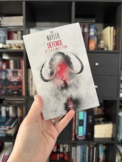 La couverture de Défense d’extinction montre un mammouth avec devant une personne levant une arme d’assaut.