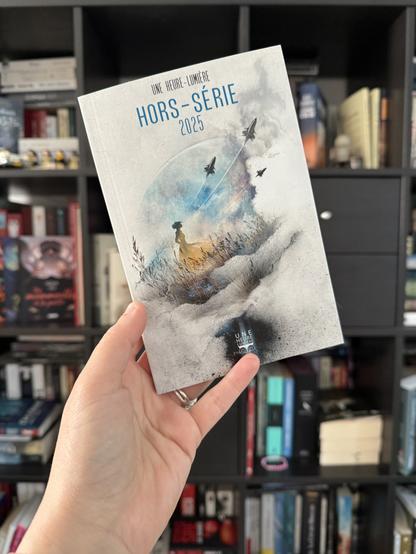 La couverture du Hors-série UHL 2025 montre une femme dans un champ regardant dans le ciel trois vaisseaux qui s’envolent devant une planète.