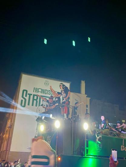 Sporting Clube de Portugal bus passing in the night with the team players on top