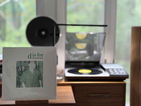 Dumptruck - d is for dumptruck LP cover.

A green-tinted photo of Seth and Kirk.

The black LP plays on a vintage, restored Bang & Olufsen Beogram 8002 linear-tracking turntable to the right.
