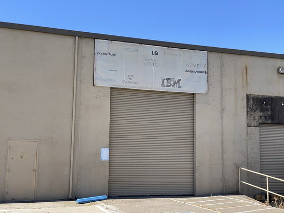 Faded signed on a warehouse with various computer manufacturer logos