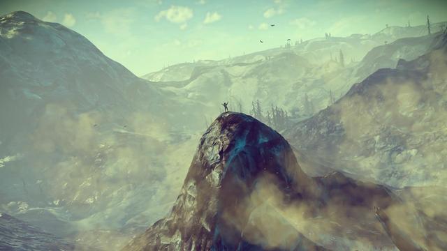 Character atop a mountain peak in the game No Man's Sky