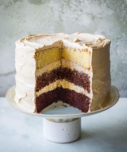 An image of a cake.  A wedge is cut out of the side facing the camera so the internal layers are visible.  It looks very delicious.