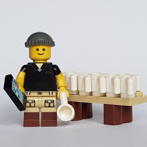 Lego Pete Carrier stands by a table filled with Freebie mugs.