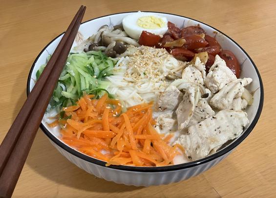 一碗豆漿麵。內容為水煮蛋半枚、炒小蕃茄、雞胸肉、紅蘿蔔絲、小黃瓜絲與炒菇。中間是關東麵與白芝麻。