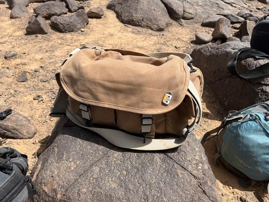 A domke bag with an ilford Pan F+ pin resting on some basalt.