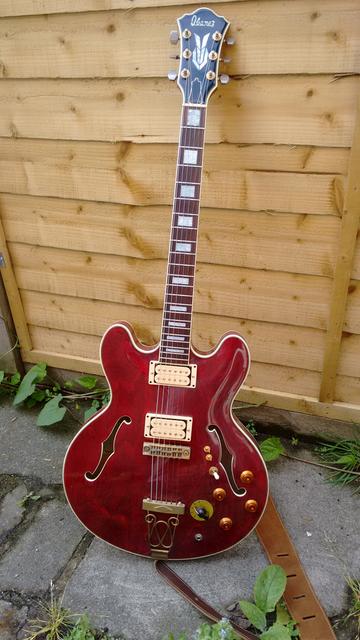 A Dark red semi acoustic guitar with cream pick-ups.  Ibanez SA400