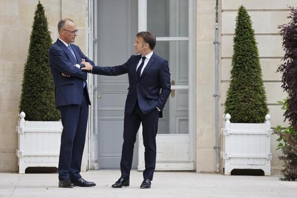 Le chancelier allemand, Friedrich Merz et Emmanuel Macron dans les jardins de l'Élysée, à Paris, le 7 mai 2025. © Photo Ludovic Marin / Pool / AFP