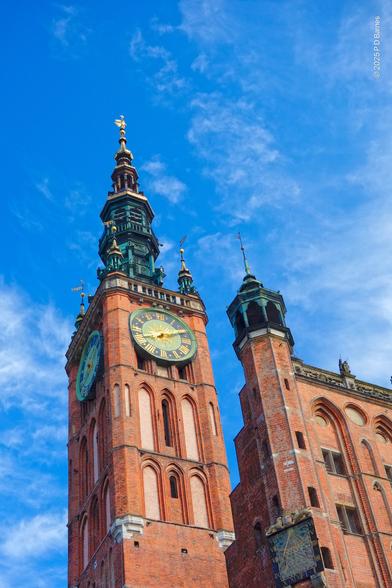 An ornate clock-tower on the Gdánsk Town Hall, seen from below  looking up. Also visible is an emergency back-up sundial.