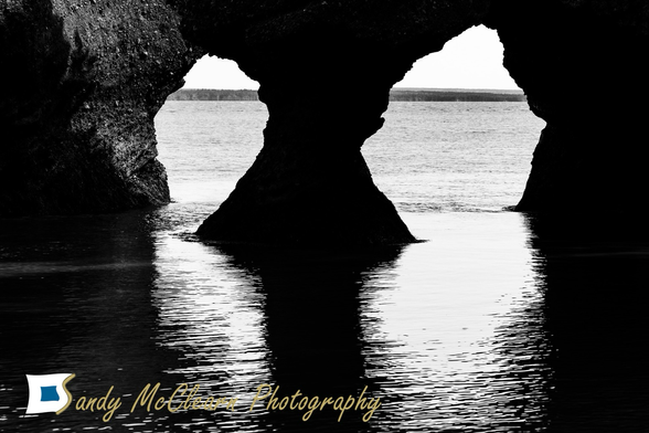 Holes looking like eyes eroded in a sandstone sea stack.