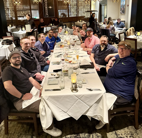 From bottom left, following clockwise: Jose Perez, Damian Edwards, Stephen Toub, Allistair Matthews, David Fowler, Glenn Condron, Maddy Montaquila, Jeff Fritz, Steve Carroll, David Negstad, Aaron Powell, David Pine, Andy De George, Brady Gaster.