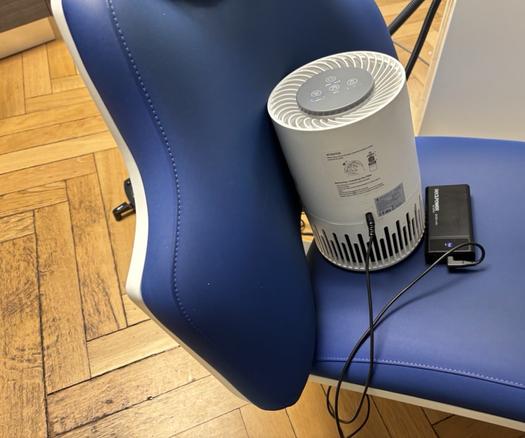 Ein Taotronics TT-AP001 Luftreiniger mit 12V PD Triggerkabel und 20k Powerbank auf einem Stuhl in der Zahnarztpraxis.