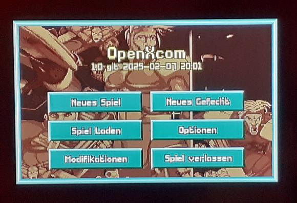 Das Startmenü von UFO/XCOM in der normalen OpenXCOM Version. Man sieht 6 türkis farbene Schaltflächen auf einem Spiele-Hintergrundbild wo man neue Spiele starten, laden oder Einstellungen vornehmen kann.