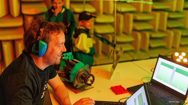 Foto der Langen Nacht der Wissenschaften 2024 zeigt eine Person mit Kopfhörern an einem Laptop im schallreflexionsarmen Raum der TUD.