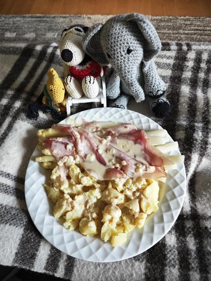 Auf einem Teller angerichtet: weiße Spargel Stangen, roher Schinken, Kartoffeln, mit heller Weißwein-Senfsahnesauce werden von Snoopy, Woodstock und Bridget begutachtet