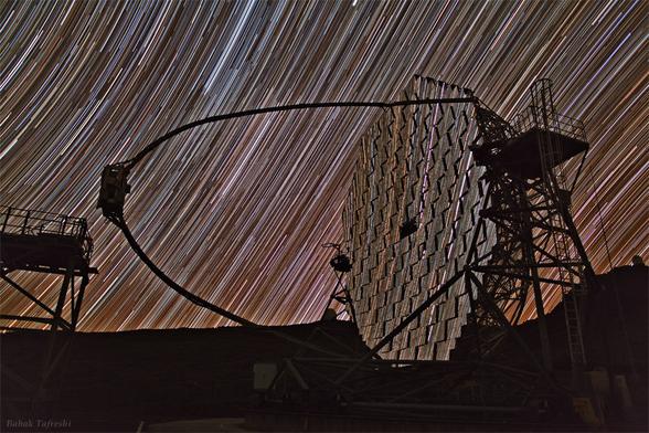 2011 October 14

MAGIC Star Trails
 * Image Credit & Copyright: Babak Tafreshi (TWAN)

Explanation: 
Colorful star trails arc across the night in this surreal timelapse skyscape from the Roque de los Muchachos Observatory on the Canary island of La Palma. A reflection of the Earth's daily rotation on its axis, the star trails are also reflected in one of a pair of 17 meter diameter, multi-mirrored MAGIC telescopes. The MAGIC (Major Atmospheric Gamma Imaging Cherenkov) telescope itself is intended to detect gamma rays - photons with over 100 billion times the energy of visible light. As the high energy gamma rays impact the upper atmosphere they produce air showers of high-energy particles. A fast camera monitoring the multi-mirrored surface records in detail brief flashes of optical light, called Cherenkov light, created by the air shower particles. Astronomers can then ultimately relate the optical flashes to cosmic sources of extreme gamma-rays. 

Authors & editors: Robert Nemiroff (MTU) & Jerry Bonnell (UMCP)
NASA Official: Phillip Newman Specific rights apply.
NASA Web Privacy Policy and Important Notices
A service of: ASD at NASA / GSFC
& Michigan Tech. U.