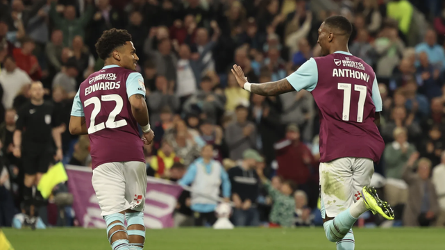 Image of Marcus Edwards and Jaidon Anthony running away from the camera and looking towards each other in 2024-5 season home kit, Edwards wearing number 22, and Anthony 11.