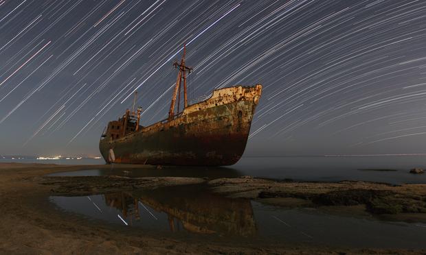 2010 October 29

Star Trails and the Captain's Ghost
 * Credit & Copyright: Chris Kotsiopoulos (GreekSky)

Explanation: 
Look closely at this surreal nightscape. In the dreamlike scene, star trails arc over an old ship run aground on a beach near Gytheio, Peloponnesus in southern Greece. Could that be the captain's ghost haunting the beach, gazing forlornly at the decaying wreck, hovering over starlight reflected in still water? Actually, the ephemeral shape is the photographer. Instead of a single long exposure to record the motion of the stars as the Earth rotates on its axis, the picture is composed of 90 consecutive images, each exposure 90 seconds long. Digitally stacking the individual exposures then reconstructs the star trails. It also creates a ghostly, semi-transparent figure of the photographer who was captured standing on the beach in only one of the exposures. 

Authors & editors: Robert Nemiroff (MTU) & Jerry Bonnell (UMCP)
NASA Official: Phillip Newman Specific rights apply.
NASA Web Privacy Policy and Important Notices
A service of: ASD at NASA / GSFC
& Michigan Tech. U.