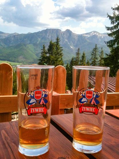 Two nearly empty beer glasses in front of a view of the Tatra mountains, Poland. Cheers!