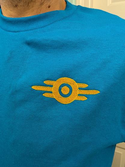Closeup of the embroidered logo, yellow and gold on a blue shirt