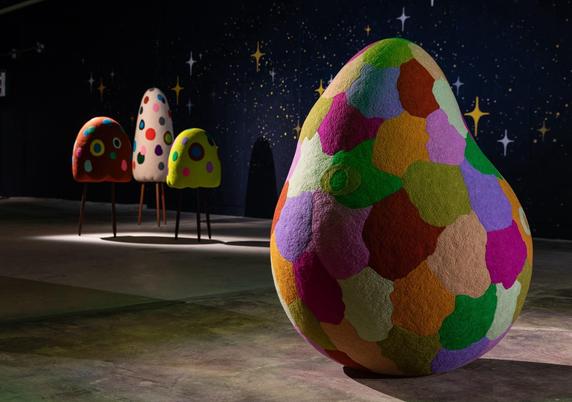 abstract, colorful, soft sculptures in a darkened gallery installation