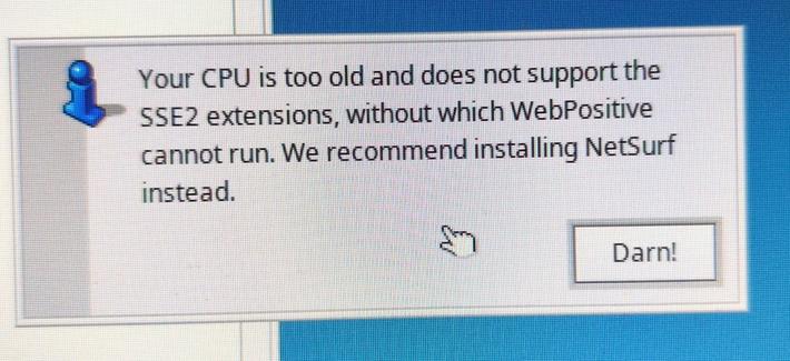 The image shows a computer screen displaying a message box. The message box has a blue icon on the left, resembling a downward-pointing arrow, and contains text in black font on a white background. The text reads: "Your CPU is too old and does not support the SSE2 extensions, without which WebPositive cannot run. We recommend installing NetSurf instead." Below the text, there is a button with the label "Darn!" in black font on a white background. The cursor is positioned over the "Darn!" button, indicated by a white hand icon. The background of the screen is a gradient of blue shades, with the message box centered on the screen.