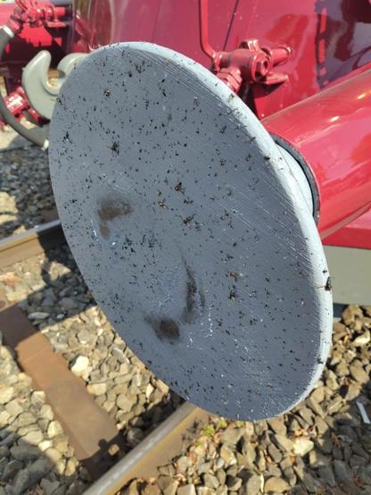 Fliegenfalle: Ein Puffer des Bahnwagens ist mit grauer, fettigen Farbe bestrichen. An dieser kleben unzählige Insekten.