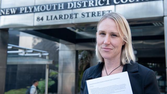 Whanganui councillor Charlotte Melser standing outside New Plymouth District Council with 3000-signature petition against seabed mining.