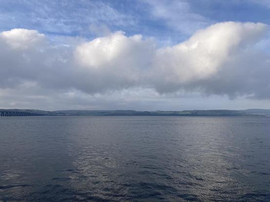 View across Tay Firth the water is dark and rippling with thick fluffy clouds overhead