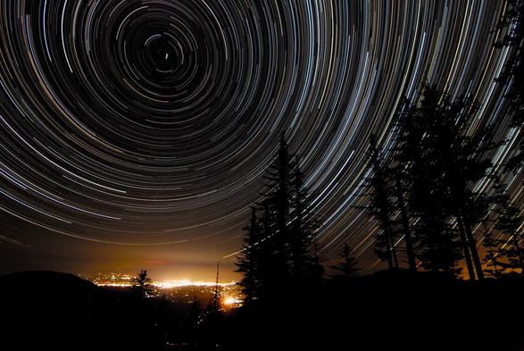2009 September 9

Star Trails Over Oregon
 * Credit & Copyright: Joshua Bury

Explanation: 
As the Earth spins on its axis, the sky seems to rotate around us. This motion, called diurnal motion, produces the beautiful concentric trails traced by stars during time exposures. Partial-circle star trails are pictured above over Grants Pass, Oregon, USA last month. Near the middle of the circles is the North Celestial Pole (NCP), easily identified as the point in the sky at the center of all the star trail arcs. The star Polaris, commonly known as the North Star, made the very short bright circle near the NCP. About 12,000 years ago, the bright star Vega was the North Star, and in about 14,000 years, as the Earth's spin axis slowly continues to precess, Vega will become the North Star again.

Authors & editors: Robert Nemiroff (MTU) & Jerry Bonnell (UMCP)
NASA Official: Phillip Newman Specific rights apply.
NASA Web Privacy Policy and Important Notices
A service of: ASD at NASA / GSFC
& Michigan Tech. U.