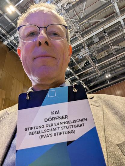 Selfie in einer Tagungshalle mit Namensschild und Orga Stiftung der Evangelischen Gesellschaft Stuttgart (eva's Stiftung).