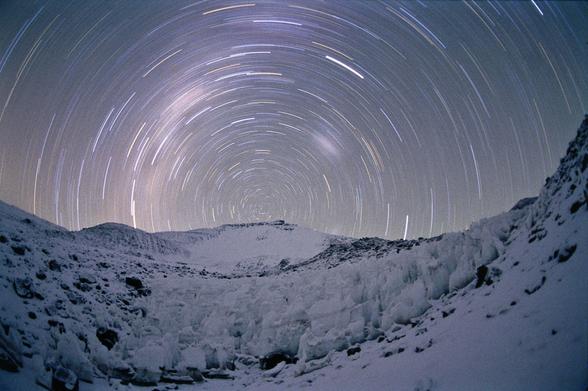 2006 December 2

Star Trails at 19,000 Feet
 * Credit & Copyright: Serge Brunier

Explanation: 
In myth, Atlas holds up the heavens, but in this stunning view a mountain appears to serve as the southern night sky pivots around a snowy peak. Recorded during a climbing expedition at an altitude above 19,000 feet (temperature -18 degrees C), the picture places the South Celestial Pole over the Andes mountain Ojos del Salado. Topping out at over 22,000 feet, the Ojos del Salado is a stratovolcano, the highest active volcano on planet Earth. The time exposure lasted for an hour, recording the graceful arcing star trails along with the rising Milky Way (left) and setting Magellanic clouds. 

Authors & editors: Robert Nemiroff (MTU) & Jerry Bonnell (USRA)
NASA Web Site Statements, Warnings, and Disclaimers
NASA Official: Phil Newman Specific rights apply.
A service of: ASD at NASA / GSFC
& Michigan Tech. U.