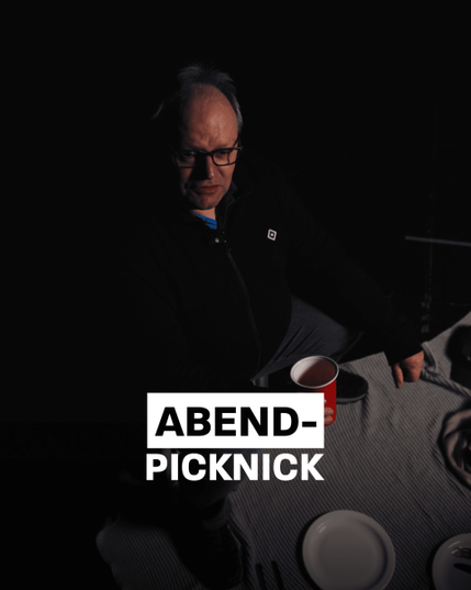 Das Bild zeigt einen Mann mittleren Alters, der in einem dunklen Raum sitzt. Er hat graues Haar und trägt eine Brille. Vor ihm auf einem Tisch mit einem grauen Tischdecken liegt ein weißer Teller und ein Besteck. Im Vordergrund des Bildes ist der Text "ABEND-PICKNICK" in großen, weißen Buchstaben auf einem schwarzen Hintergrund zu sehen. Die Atmosphäre des Bildes ist gedämpft und intim, mit einem Fokus auf den Mann und den Text.

Bereitgestellt von @altbot, privat und lokal generiert mit Ovis2-8B, bearbeitet
