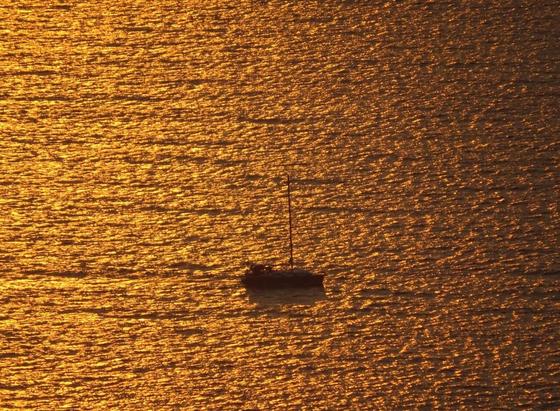The dark silhouette of a sailing boat with furled sails in the middle of a golden sea at sunset.

Die dunkle Silhouette eines Segelbootes mit eingerollten Segeln inmitten eines goldenen Meeres im Sonnenuntergang.