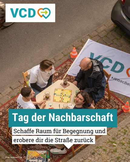 Man sieht vier Menschen, die um einen Tisch herum sitzen und ein Brettspiel spielen. Der Tisch steht auf einem Teppic, der offenbar auf einem Parkplatz ausgelegt wurde.
Text im Bild: Tag der Nachbarschaft
Schaffe Raum für Begegnung und erobere dir die Straße zurück