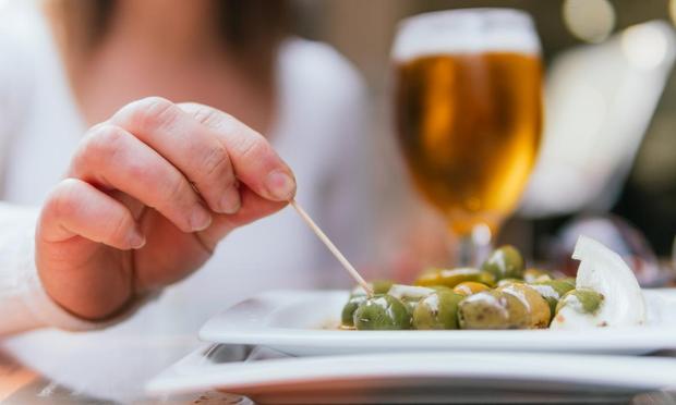 Una persona, comiendo aceitunas en un bar. (GETTY)