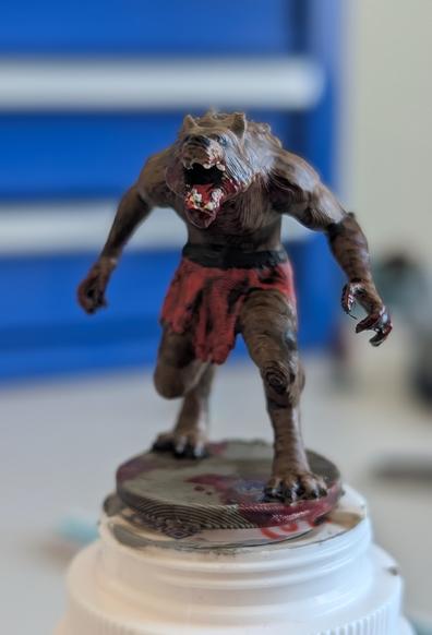 Front view of a brown werewolf mini stuck to the top of a medicine bottle