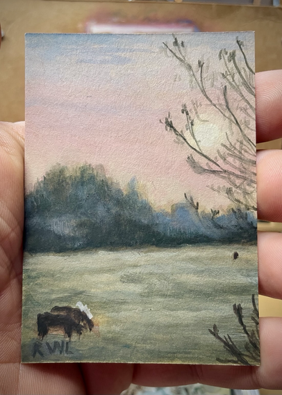 Miniature painting, held in the palm of a hand, of a field at sunset with two cows in the foreground, hazy backlit trees in the background, and branches of a single tree coming in from the right side also in the foreground.