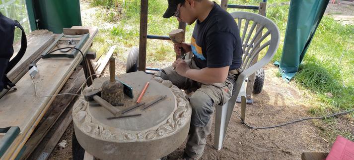 Ein kritischer Blick, und dann geht es weiter. Hier sieht man unseren Gesellen am Stein kurz bevor er weiterarbeitet. 
Den Holzhammer, den er in der Hand hält, nennt man übrigens "#Knüpfel". 
Für Nicht-Steinmetz*innenn hört sich das vielleicht nach Dialekt an, aber es ist tatsächlich die offizielle Bezeichnung für dieses Werkzeug.