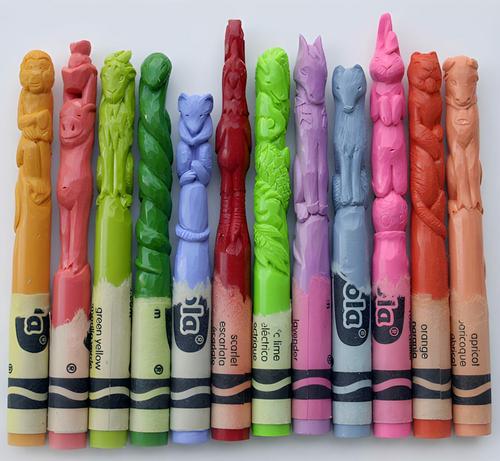 Photo of a row of different coloured crayons with tops carved in images of creatures such as a bear or a monkey