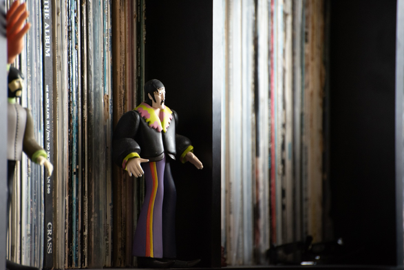 Yellow Submarine figures of George and John stand on a shelf full of LPs.