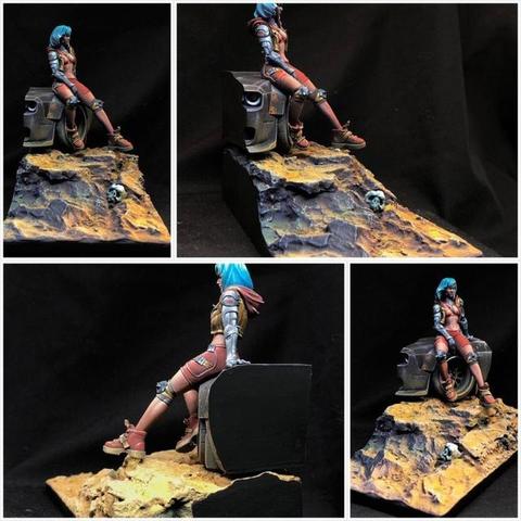 This set of four images provides multiple perspectives of a masterfully crafted diorama featuring a striking character and an evocative environment. The figure—a futuristic, battle-worn woman — sits atop a mechanical remnant in a barren, desolate landscape. Each angle emphasizes different details, revealing the layers of storytelling embedded in the composition.