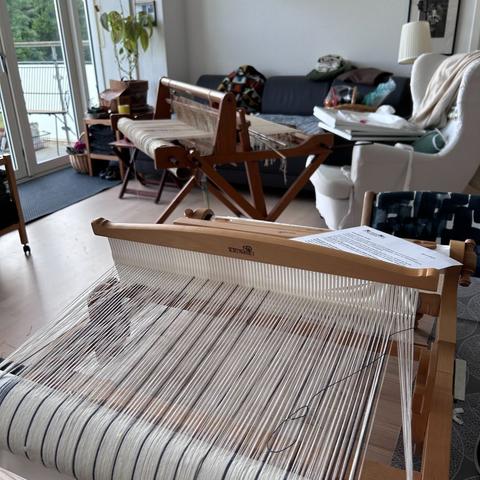 En bordvæv på spisebordet, en klapvæv foran lænestolen. Dimser og opslagsbøger rundt omkring.