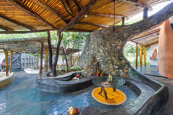 the interior of a biophilic residential design, with wood-beamed ceilings, organic walls, and earthy floors