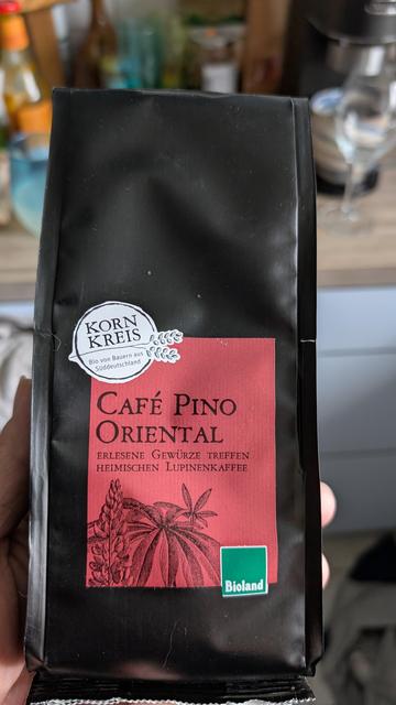 Eine Packung Lupinenkaffee. Schwarze Verpackung, rotes Etikett mit der Aufschrift Café Pino Oriental